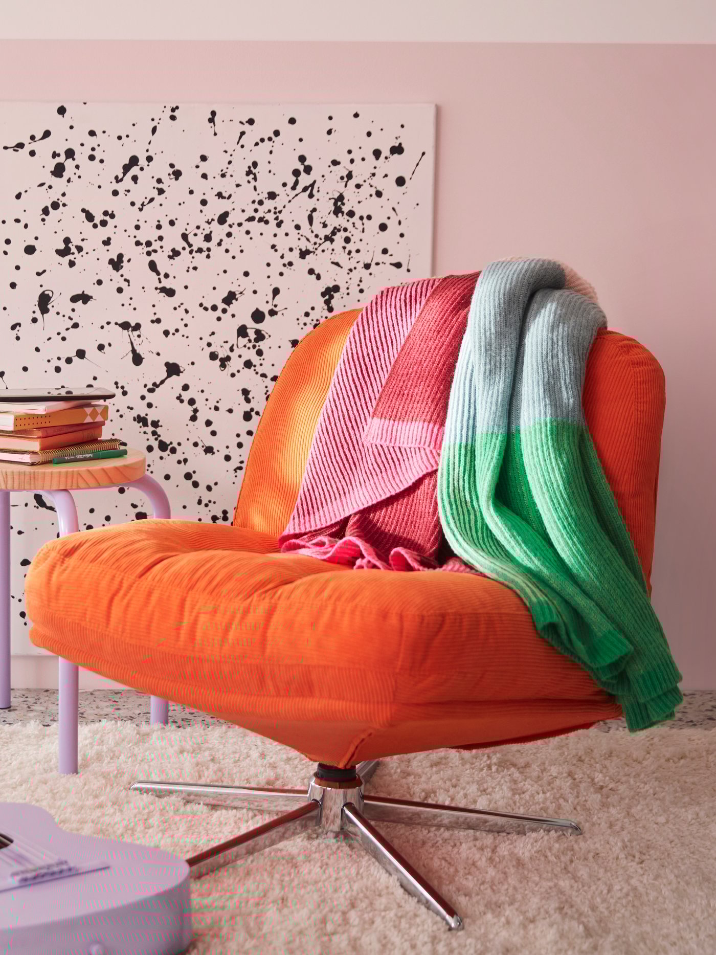 Ein Schlafzimmer zeigt eine mehrfarbige MARGOSATRÄD Decke, die auf einem Kelinge orangefarbenen DYVLINGE Drehstuhl liegt.