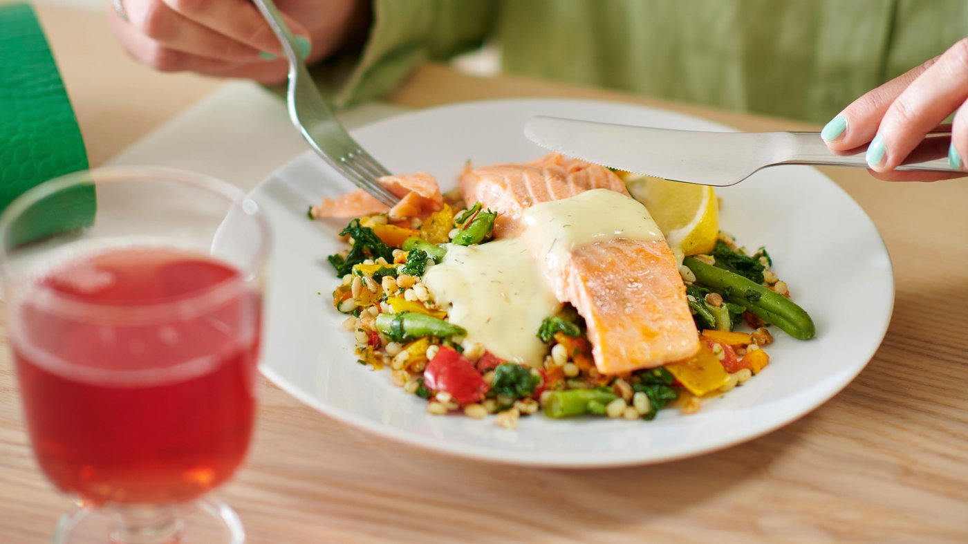 A person eating a salmon fillet