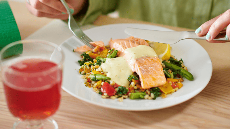 A person eating a salmon fillet