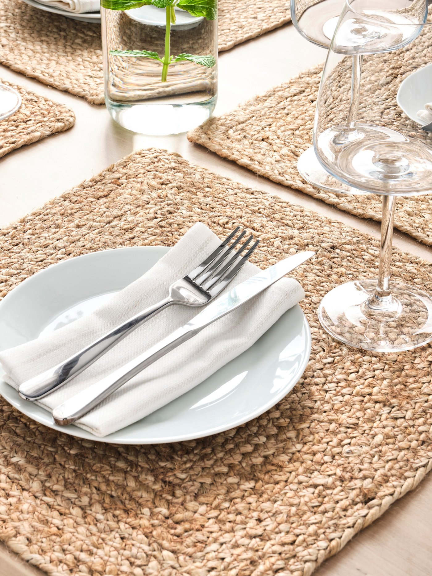 MARTORP Besteck aus Edelstahl liegt auf einer weißen Serviette auf einem weißen Teller