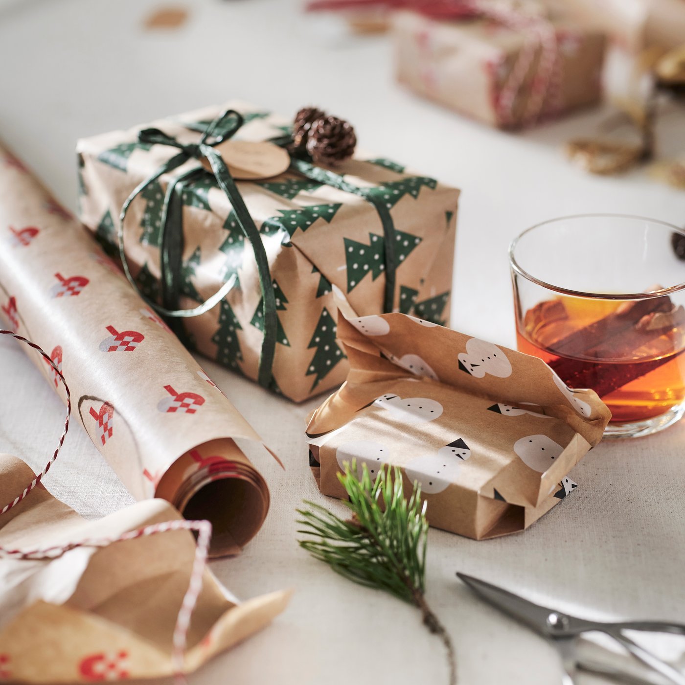 Kerstcadeaus in kraftpapier met groen lint, dennentakjes en houten decoratie