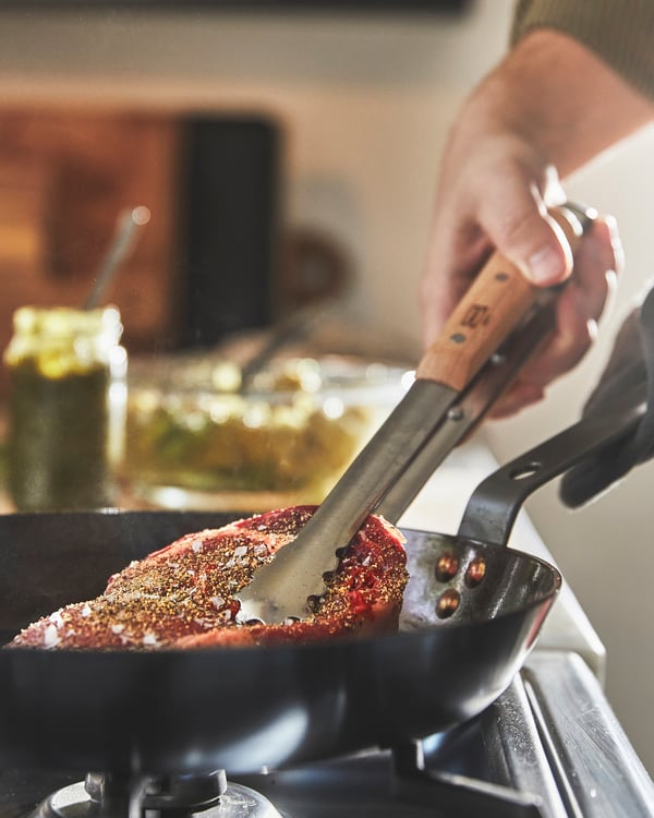 Una pentola VARDAGEN  con all'interno una bistecca durante la cottura