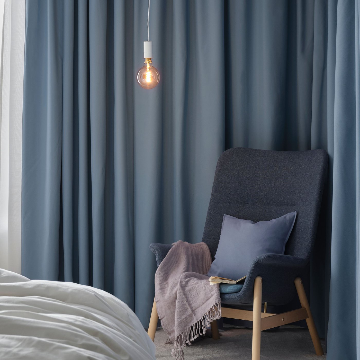 Una butaca de respatller alt VEDBO en Gunnared blau al dormitori.
