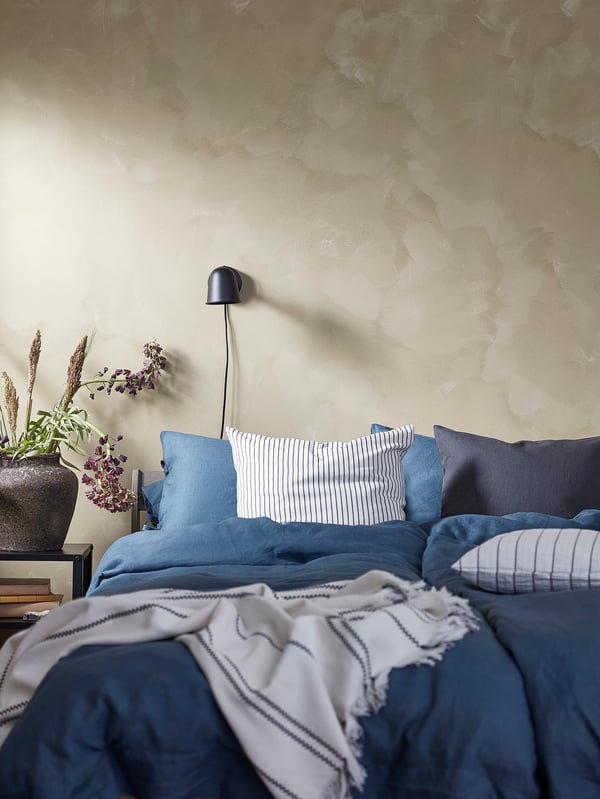 A black SKURUP wall lamp in the bedroom