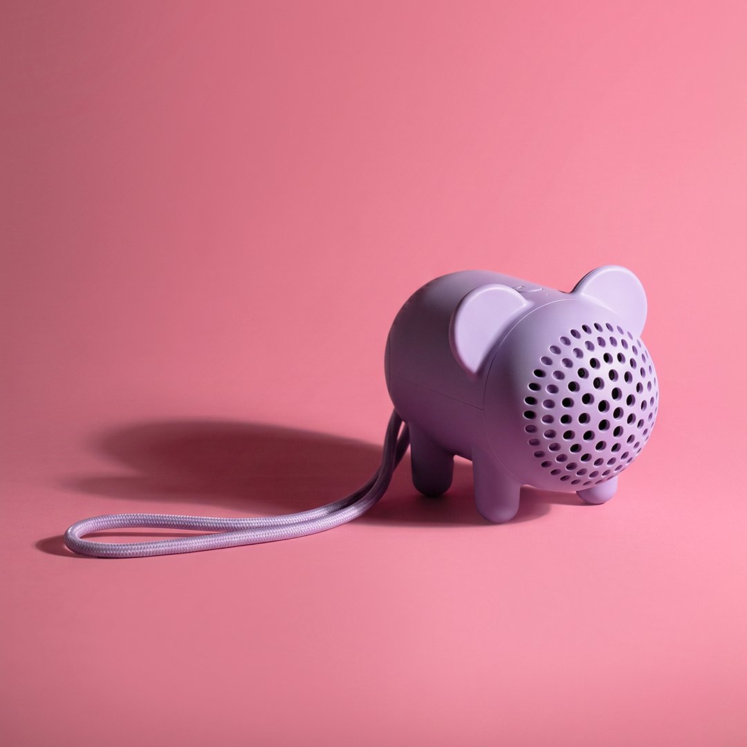 Enceinte violette en forme de cochon sur fond rose