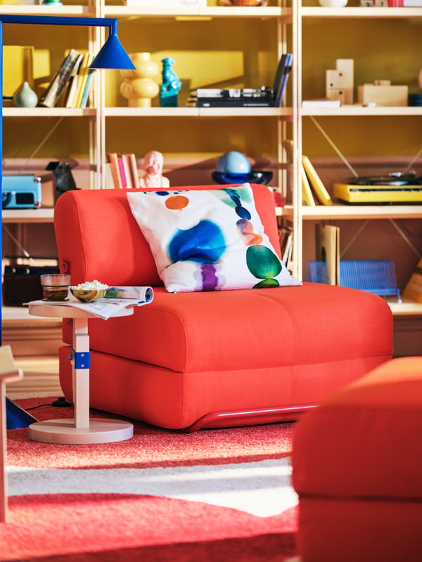 A Skiftebo bright orange IKEA PS 2026 chair-bed in the living room