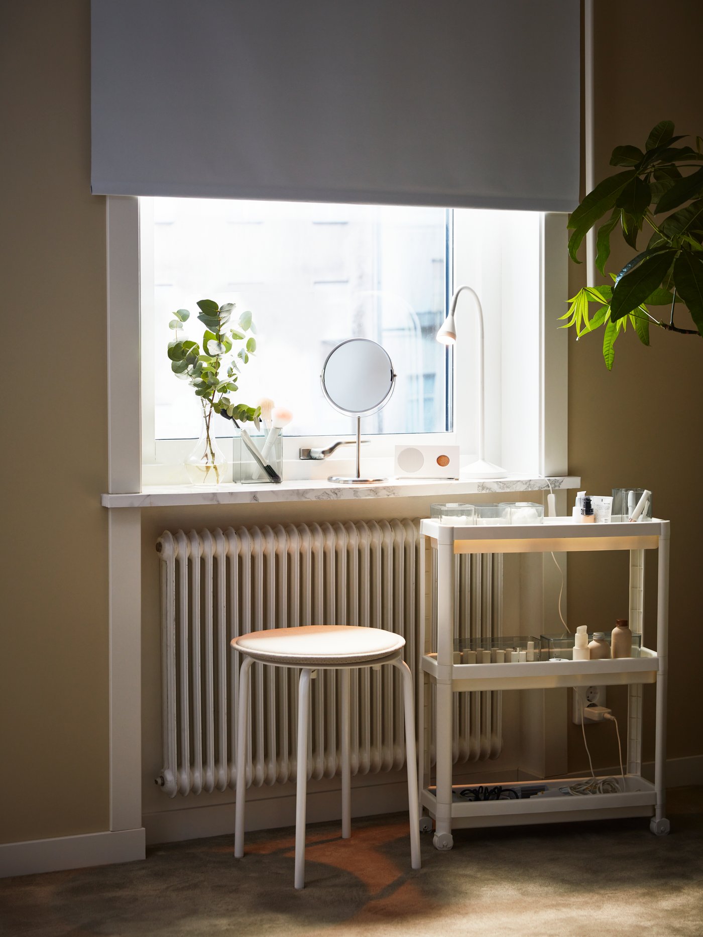 Ein weißes FÖNSTERBLAD Verdunkelungsrollo hängt vor einem lichtdurchfluteten Fenster. Durch das geschlossene Rollo fällt kein Licht herein.