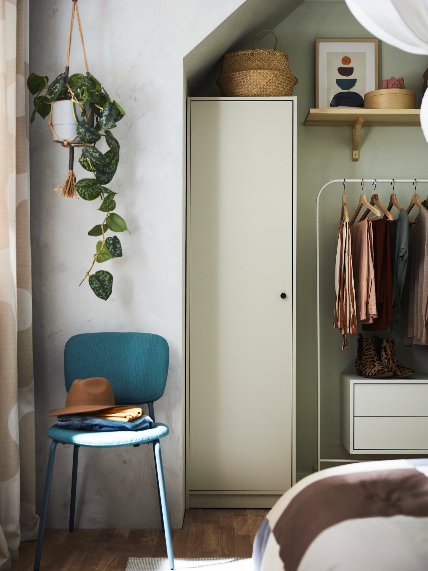 Pieza para bebés y niños con un mueble beige de madera, un canasto redondo, una silla turquesa y un perchero blanco.