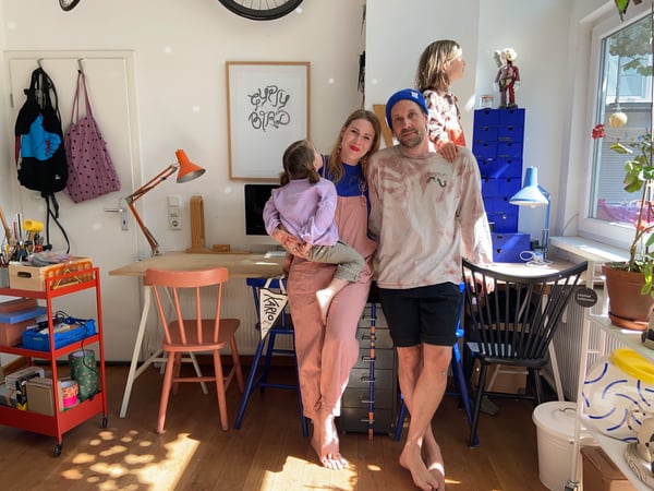 Anna and her family in their house, leaning n work desks with different storage solutions around them.