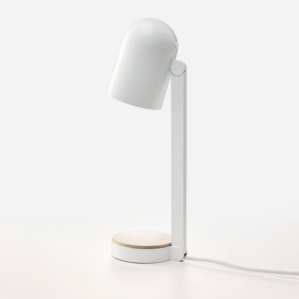 En hvid ENSMÄRKE skrivebordslampe, der står alene på en lys overflade, med lampen rettet næsten lige ned.