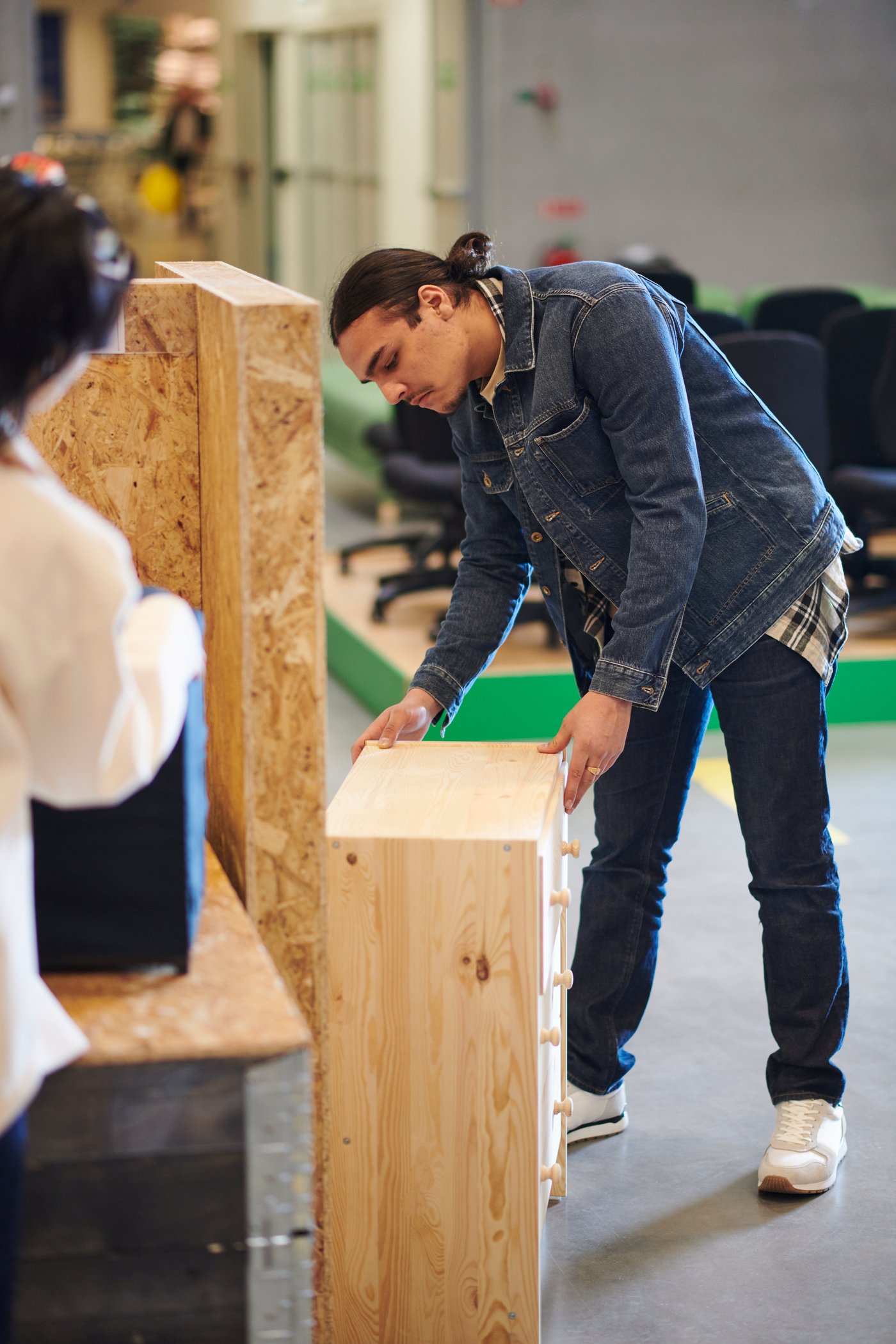 En man står och kollar på ett träskåp.