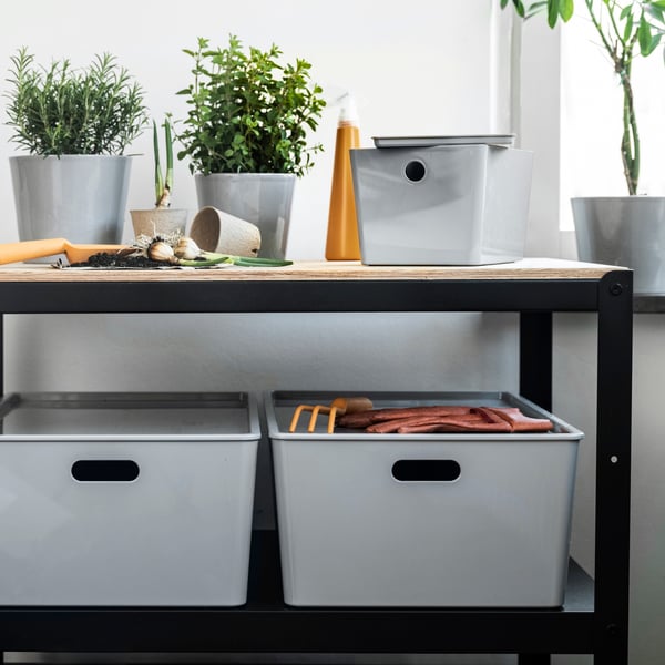 KUGGIS boxes storing gardening supplies on a BROR shelving unit