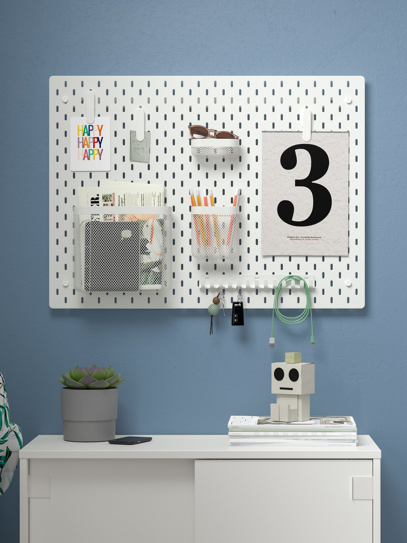 A white memo board with a newspaper, card, sunglasses and pen organized on it