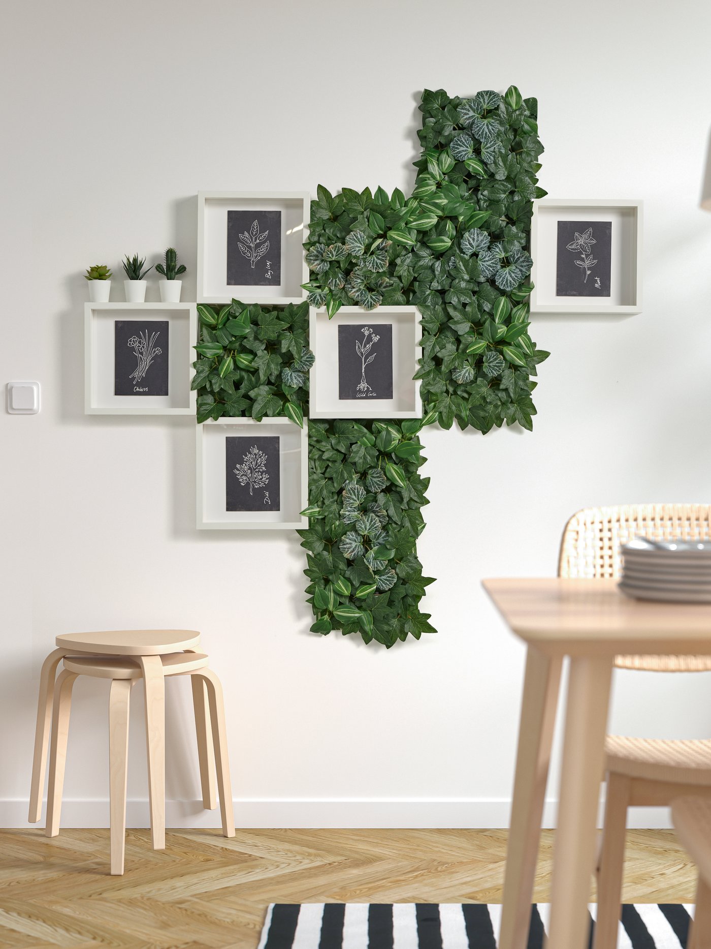A wall with white frames and wall decoration with artificial grass.