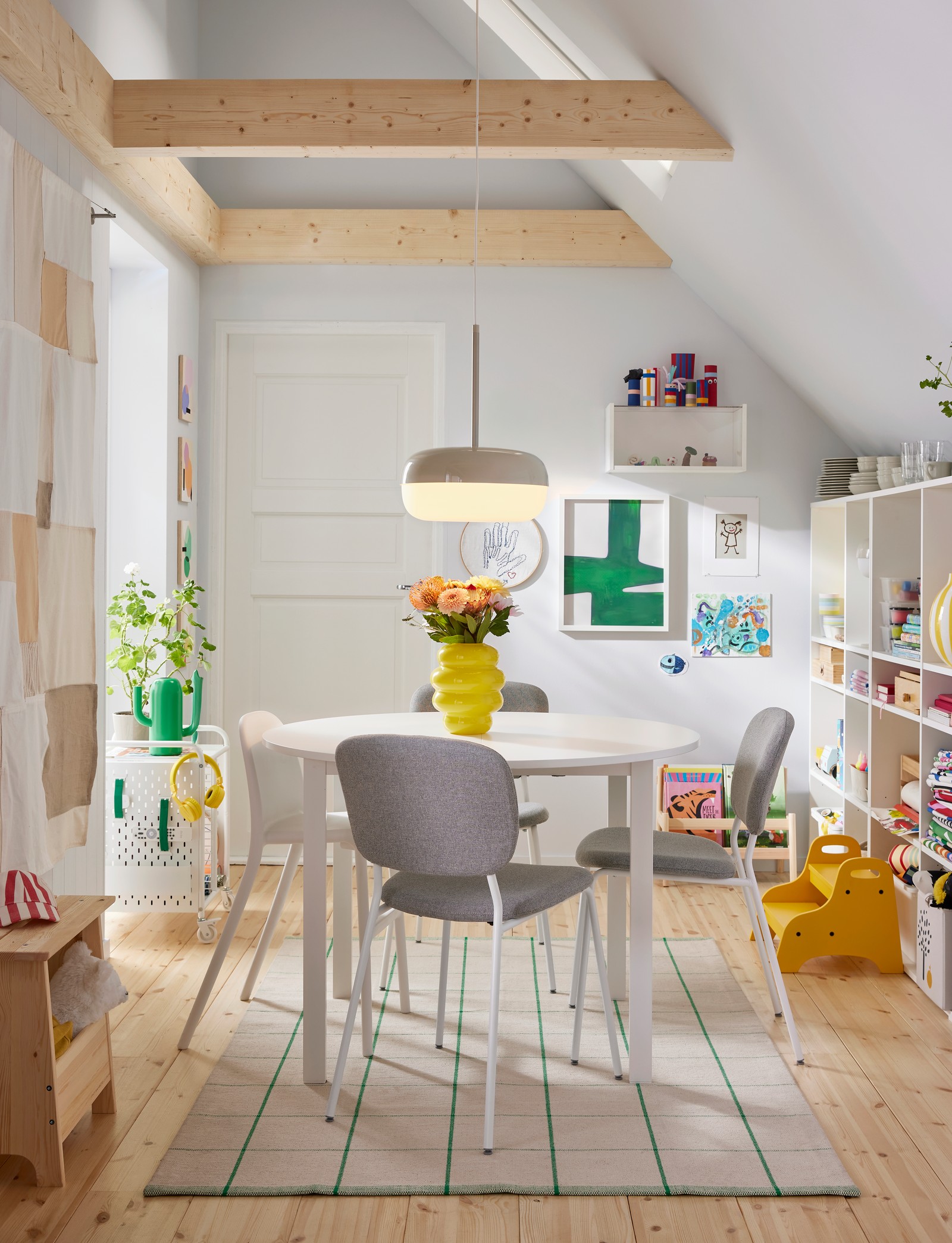 VIHALS chairs and an URBAN junior chair stand at a round VIHALS table on a RIDSTIG rug near a PERJOHAN stool with storage.