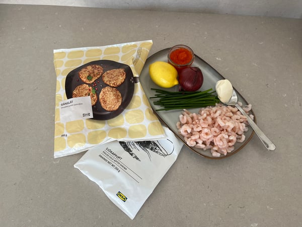 Ingredienser till potatisrösti med räkor och kaviar ligger uppdukat på en köksbänk, inklusive GÅNGLÅT potatispannkakor, SJÖRAPPORT räkor och grönsaker.