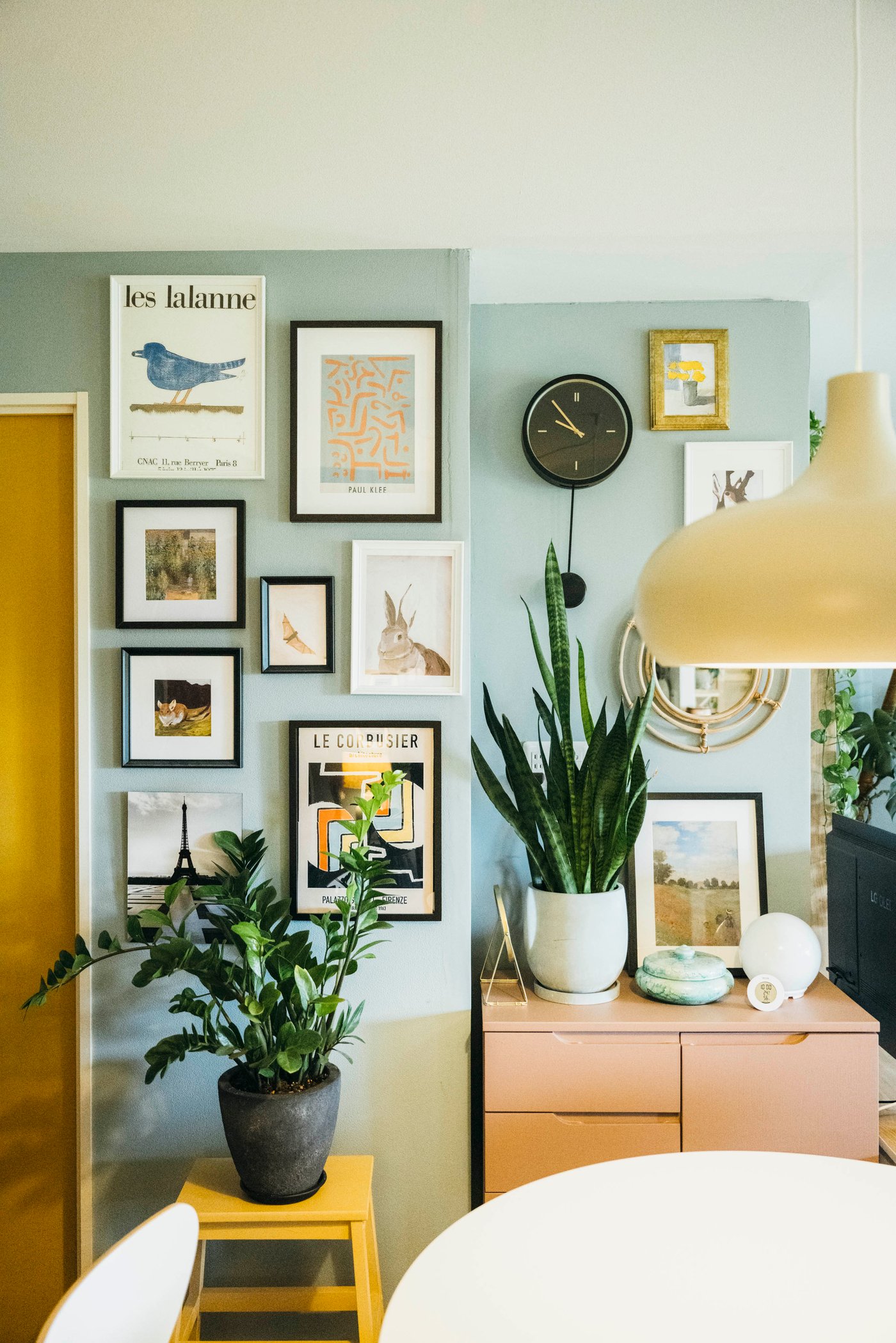 淡い色の壁紙にはたくさんの絵が飾られている。