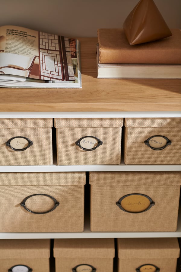 Eine beige KVARNVIK Aufbewahrungsbox mit Deckel im Homeoffice