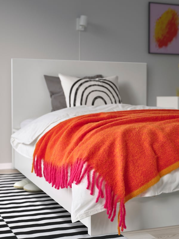 An orange/bright pink KLIPPOXEL throw