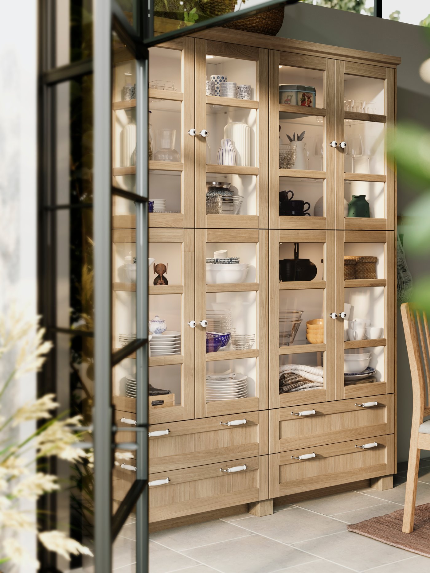 Eine Küchenvitrine mit Fronten aus hellem Holz und Glas aus unserer FORSBACKA Serie.