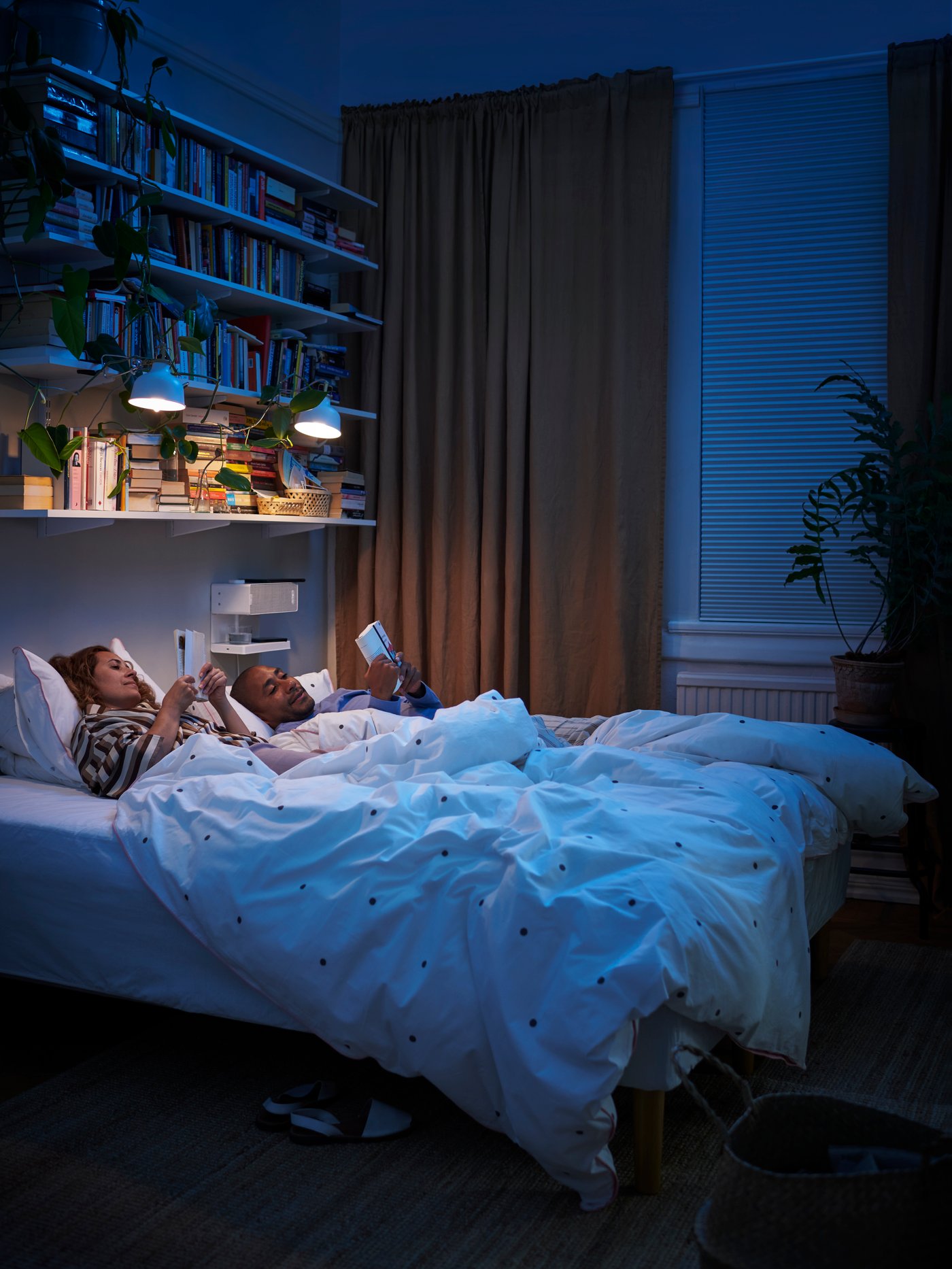 Ett mörkt rum med två personer som ligger i sängen.