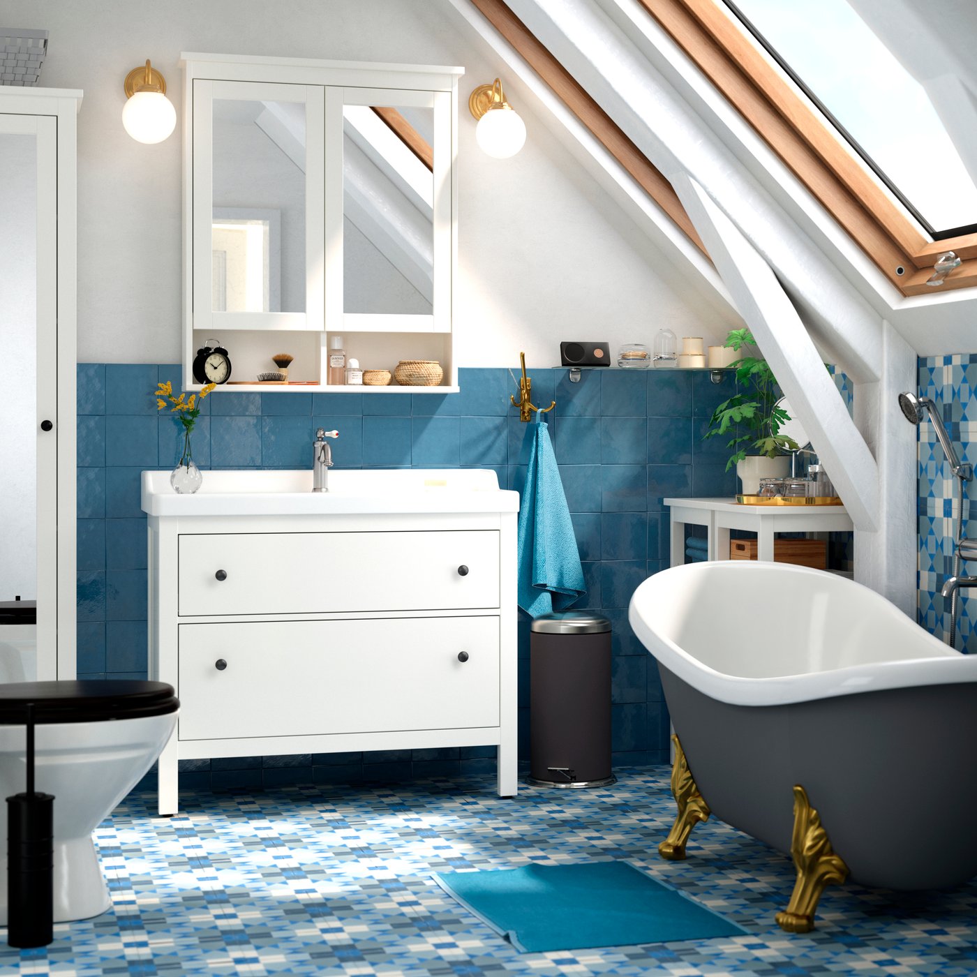 Stilvolles Badezimmer mit Dachfenster, weißem Waschtisch, freistehender Badewanne mit goldenen Füßen & blauen Fliesen.