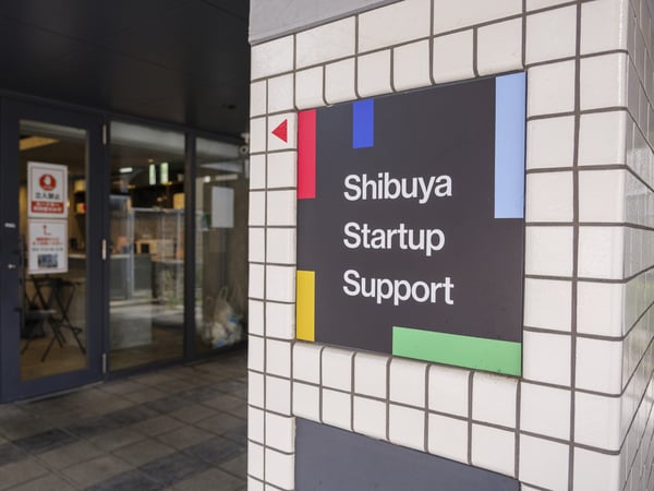 渋谷スタートアップ支援施設の入口。カラフルな看板とガラス扉が特徴の現代的な建物