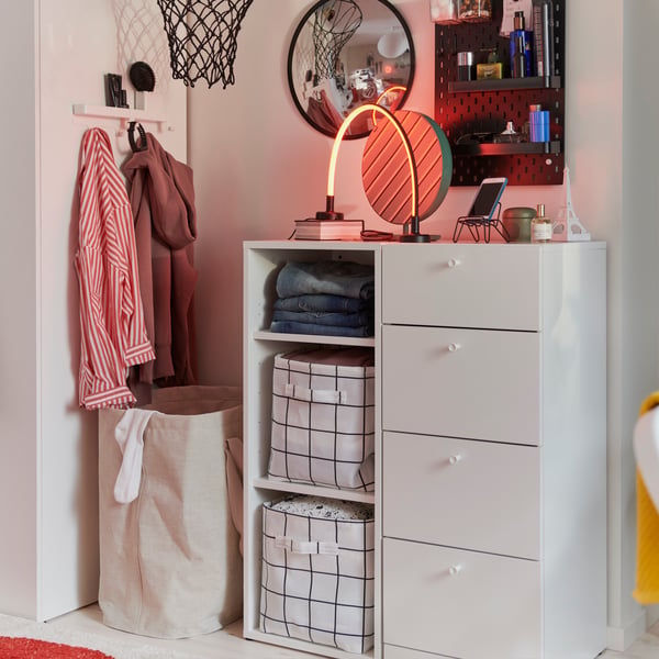 A child’s room features a white LASTARE chest of 4 drawers, with neatly folded clothes and a mirror on top.