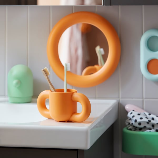 orange mirror and cut placed in bathroom