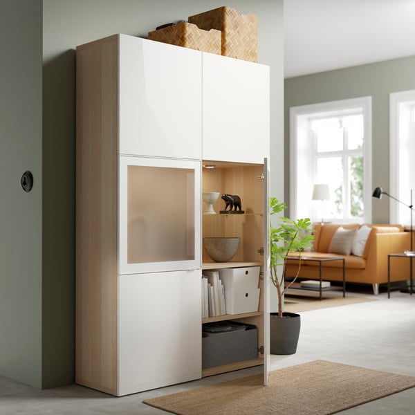 BESTA storage cabinet in the living room hallway with one door open and showing items stored inside. 