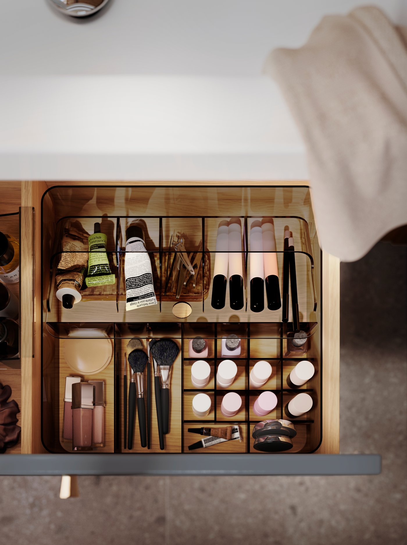 A grey VISSLAÅN box with compartments, inside a pulled-out bathroom drawer, stores many makeup products and bathroom items.