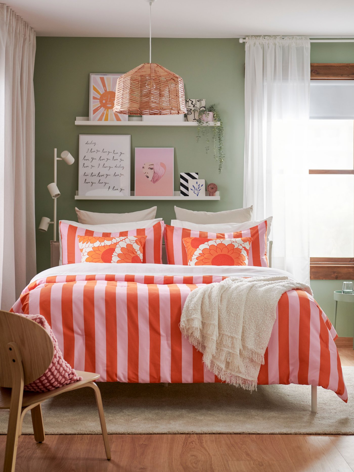 Lit avec housse de couette rayée rouge et rose.