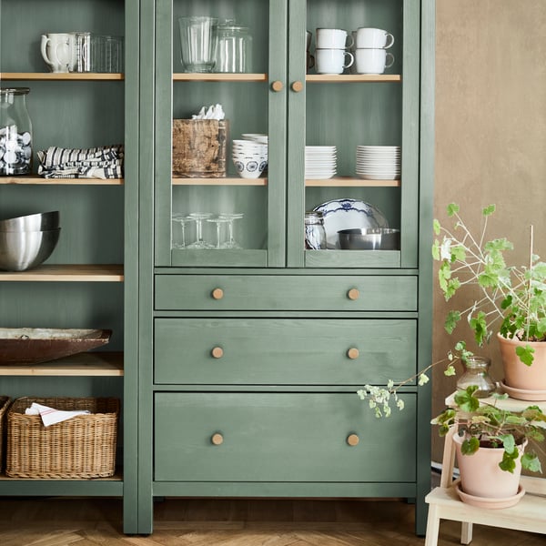 Ein grau-grün/hellbraun gebeizter HEMNES Glastürenschrank mit 3 Schubladen