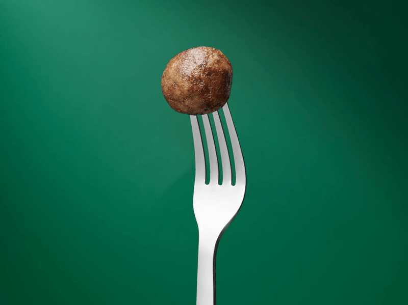 Perjantaipyörykkä haarukassa kiinni vihreällä taustalla.