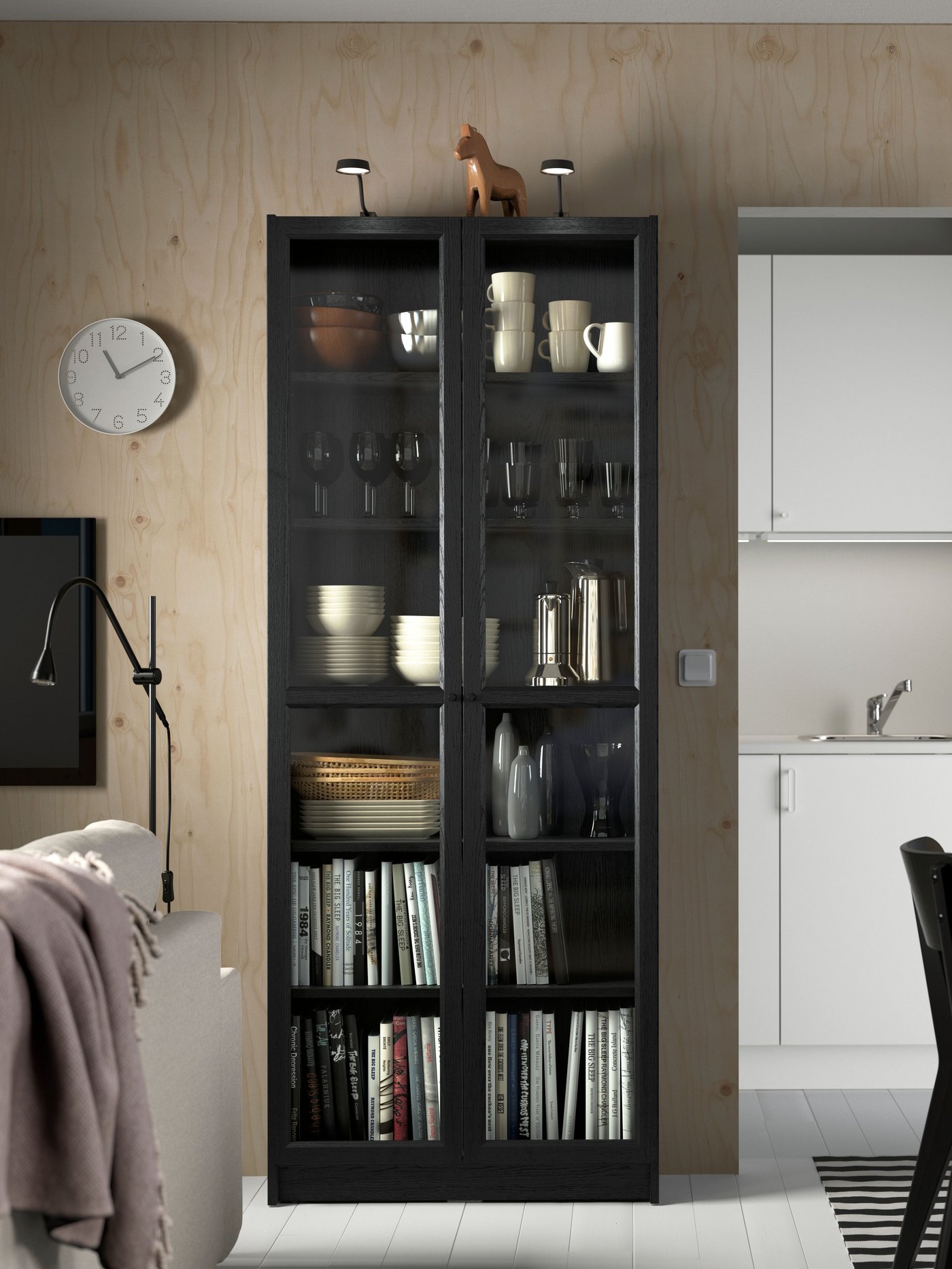 Ein schwarzes BILLY Bücherregal mit Vtrinentüren.