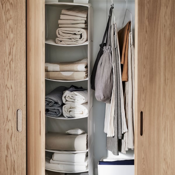 White/oak veneer PAX/TONSTAD wardrobe with open doors shows a white SKUBB hanging storage with 6 compartments inside.