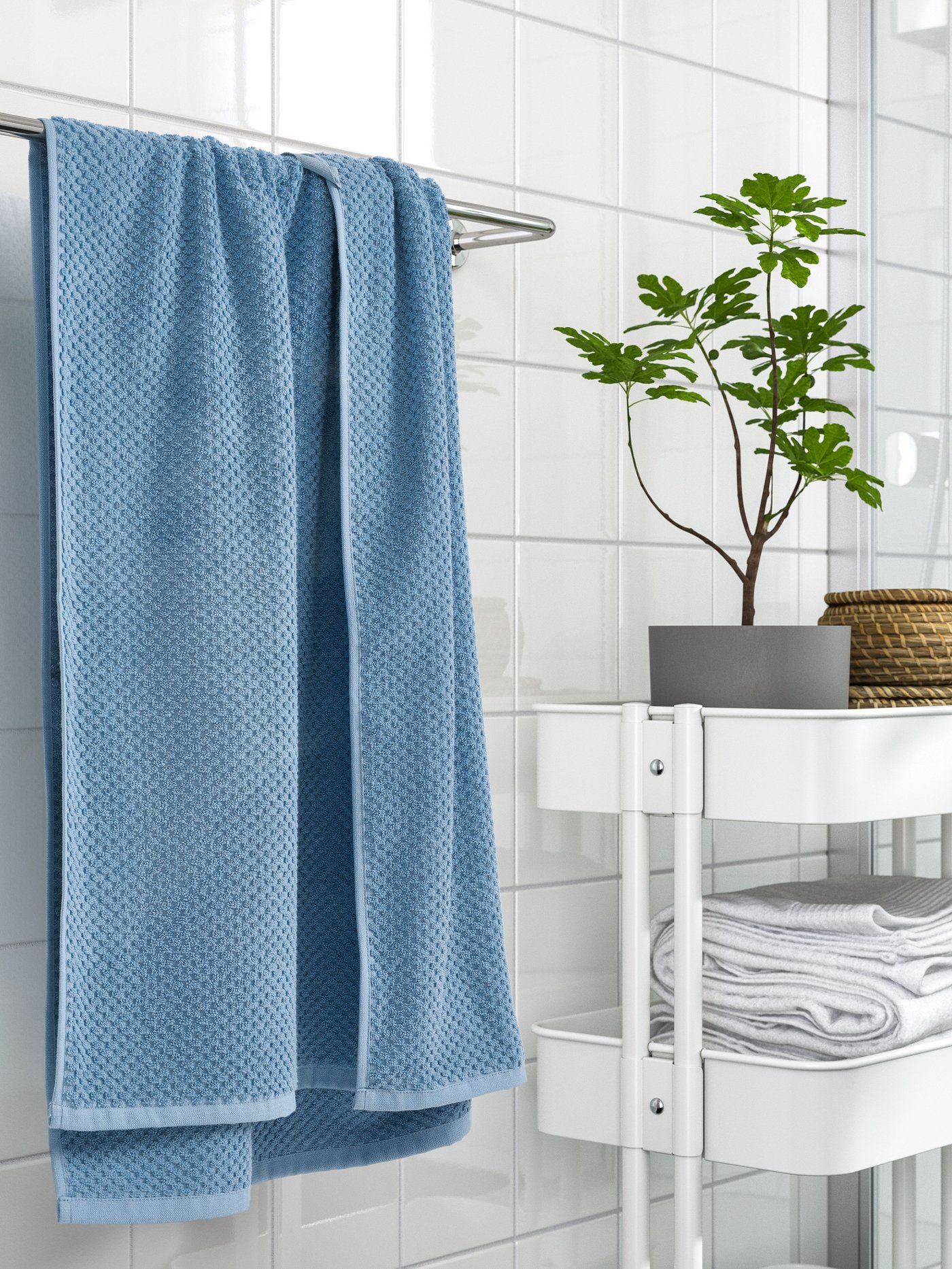 Toalla de baño de cuerpo celeste GULVIAL en pared blanca.