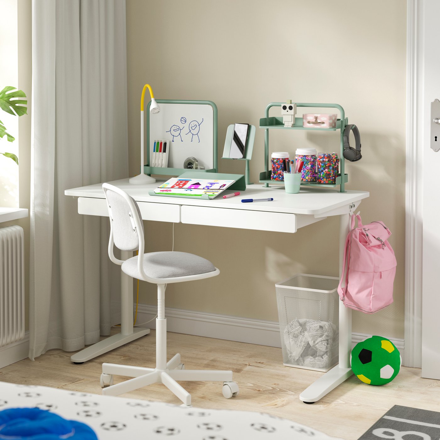Un ensemble de bureau RELATERA blanc/gris-vert clair dans la chambre d'enfant