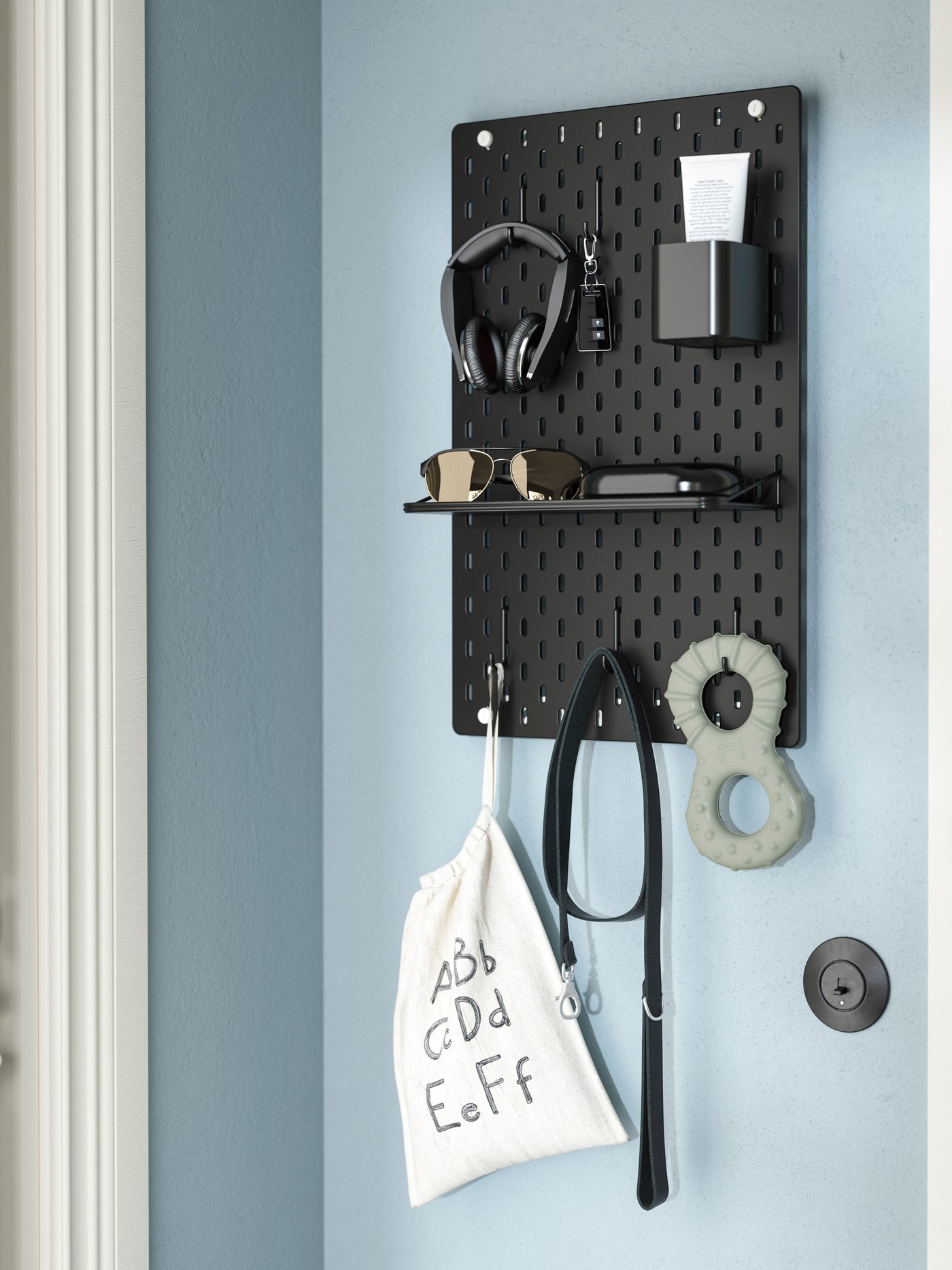 Ein schwarzes SKÅDIS pegboard and dem unterschiedliche Utensilien aufgehängt sind. 
