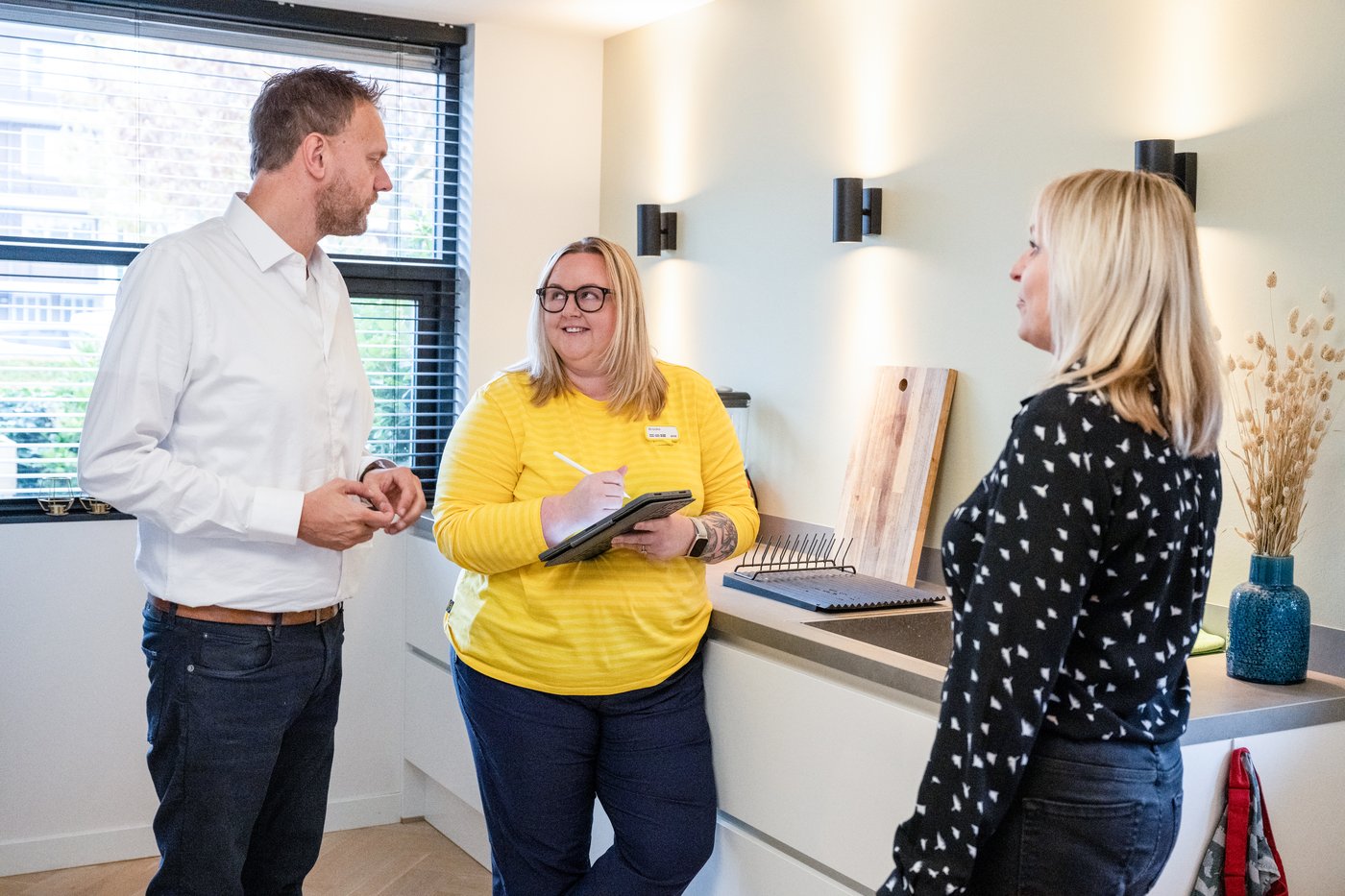 Stranki se posvetujeta z zaposleno v podjetju IKEA glede opremljanja prostora.