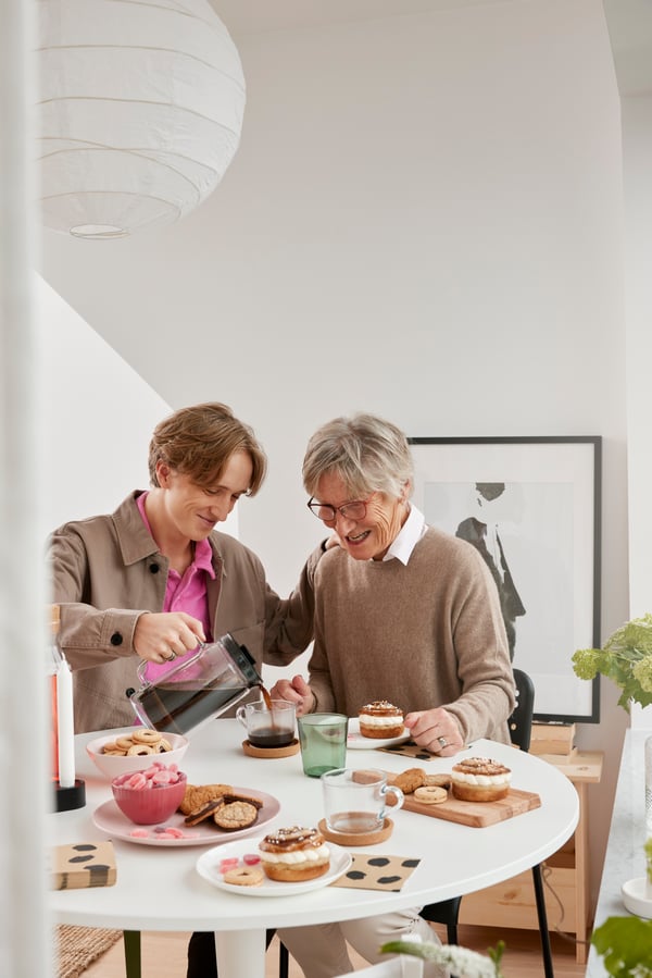 Zwei Personen trinken zusammen Kaffee am Tisch.