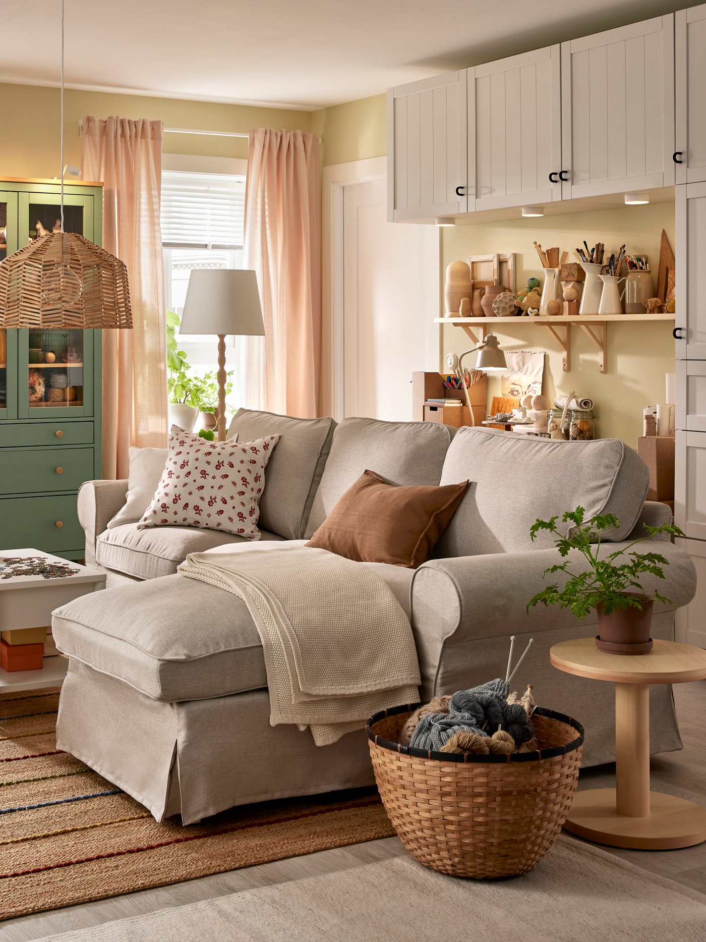 An EKTORP sofa with chaise longue stands in a functional living room near a HEMNES glass-door cabinet and some BESTÅ storage.