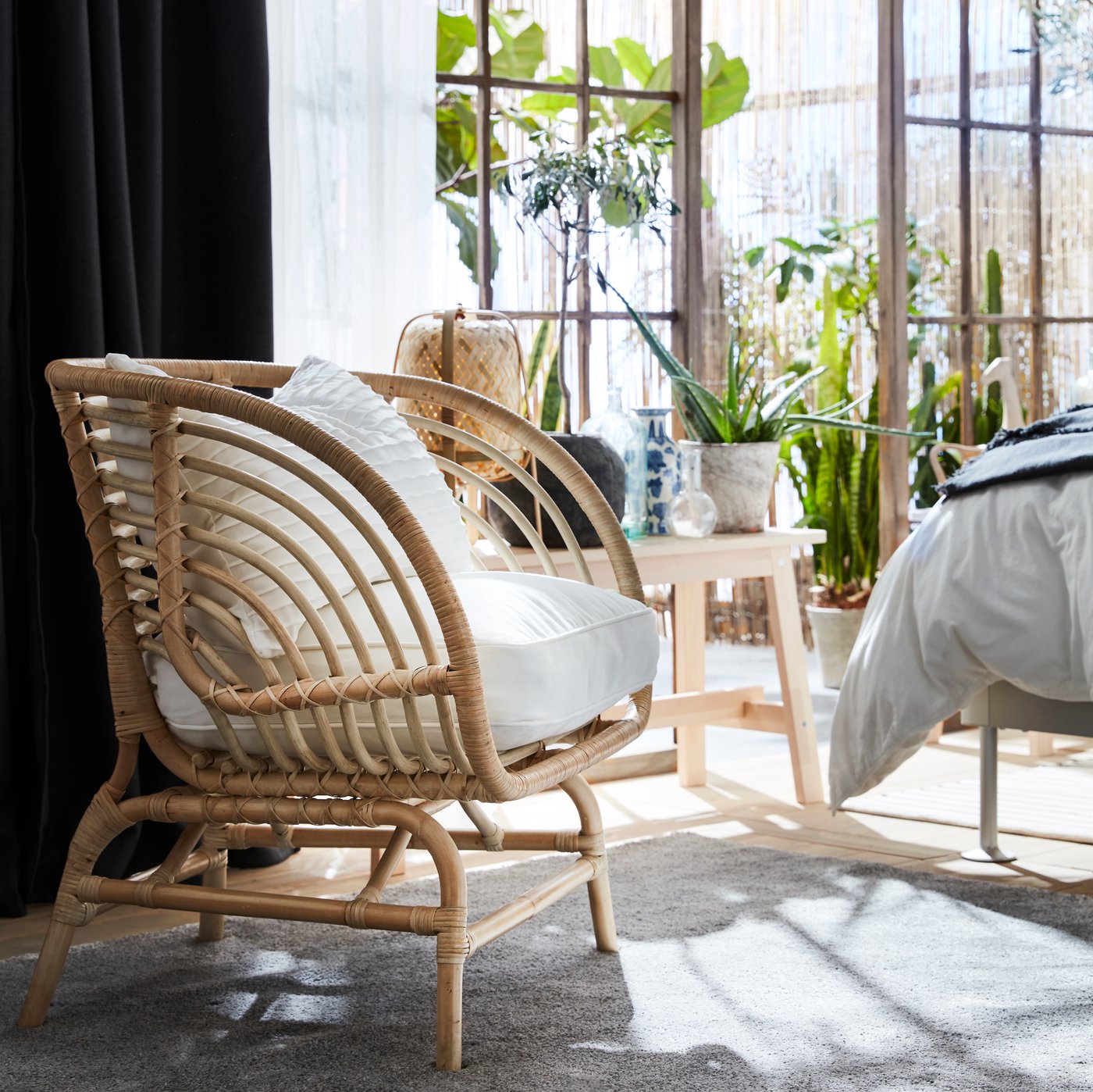A rattan/Djupvik white BUSKBO armchair in the bedroom