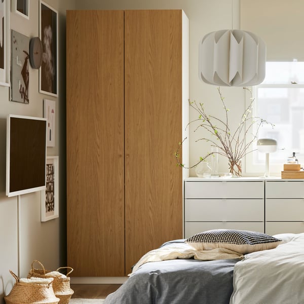A beige/black KUSTFLY cushion cover in the bedroom