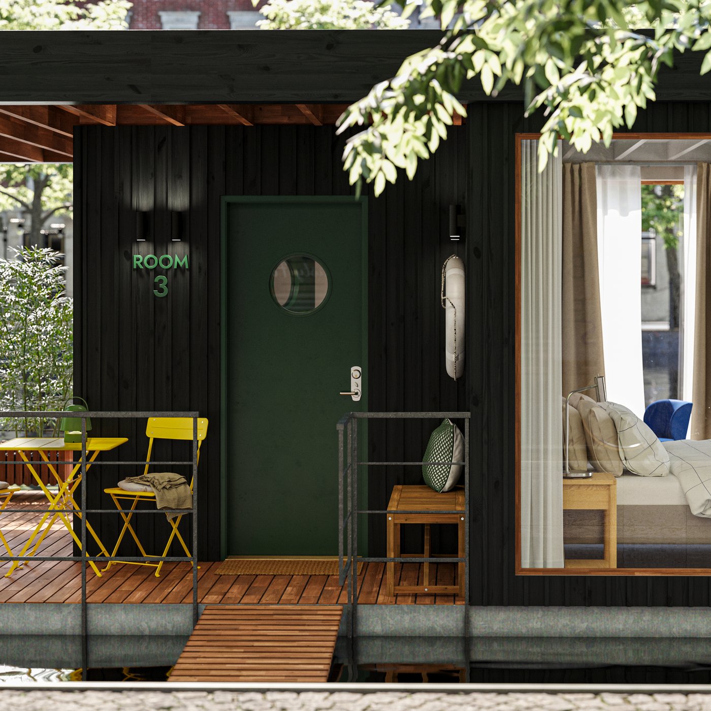 The deck of a small houseboat hotel floating on water in an urban context. One room with a bed can be seen through a window.