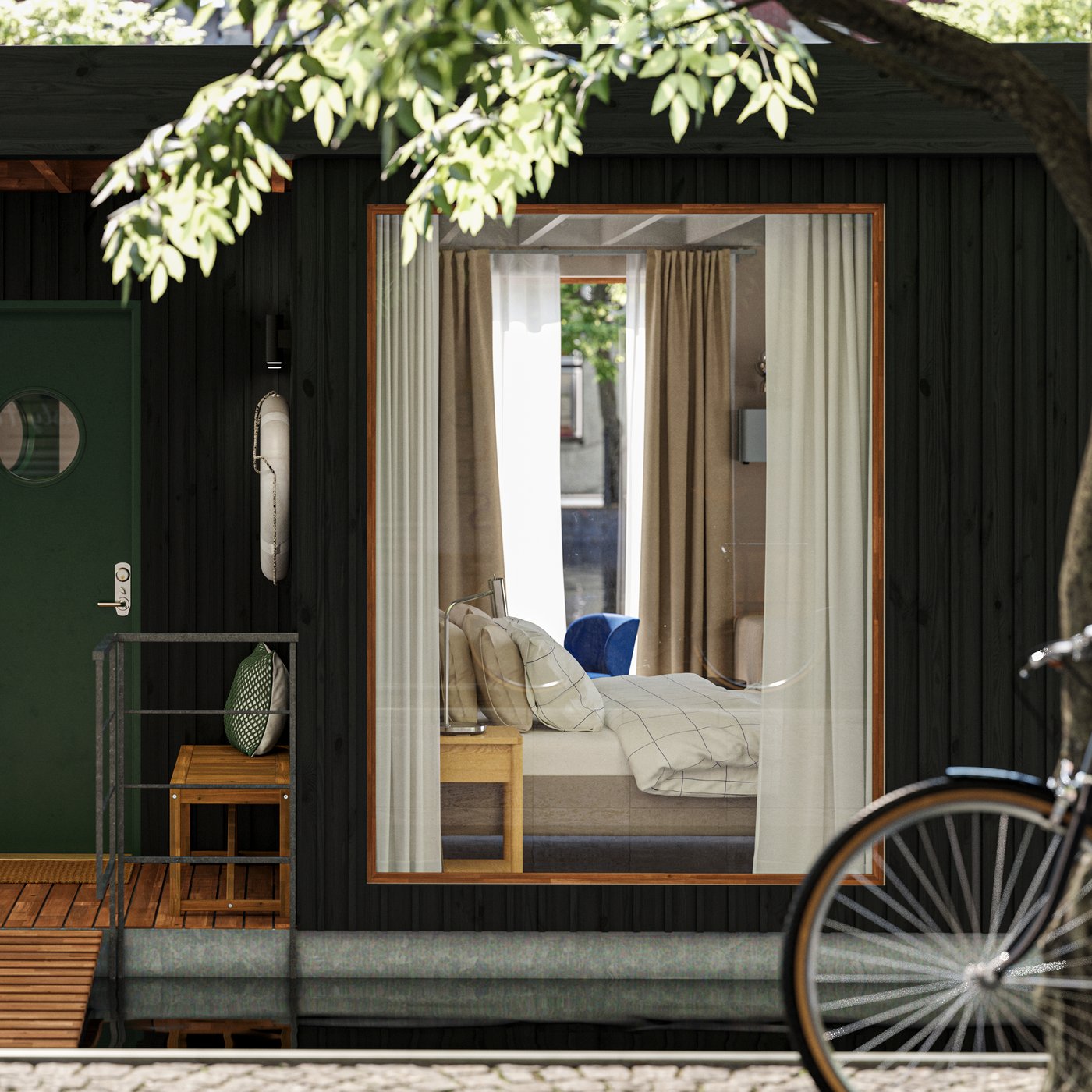 Däcket på ett litet husbåtshotell som flyter på vattnet i en urban miljö. Ett rum med en säng kan ses genom ett fönster.