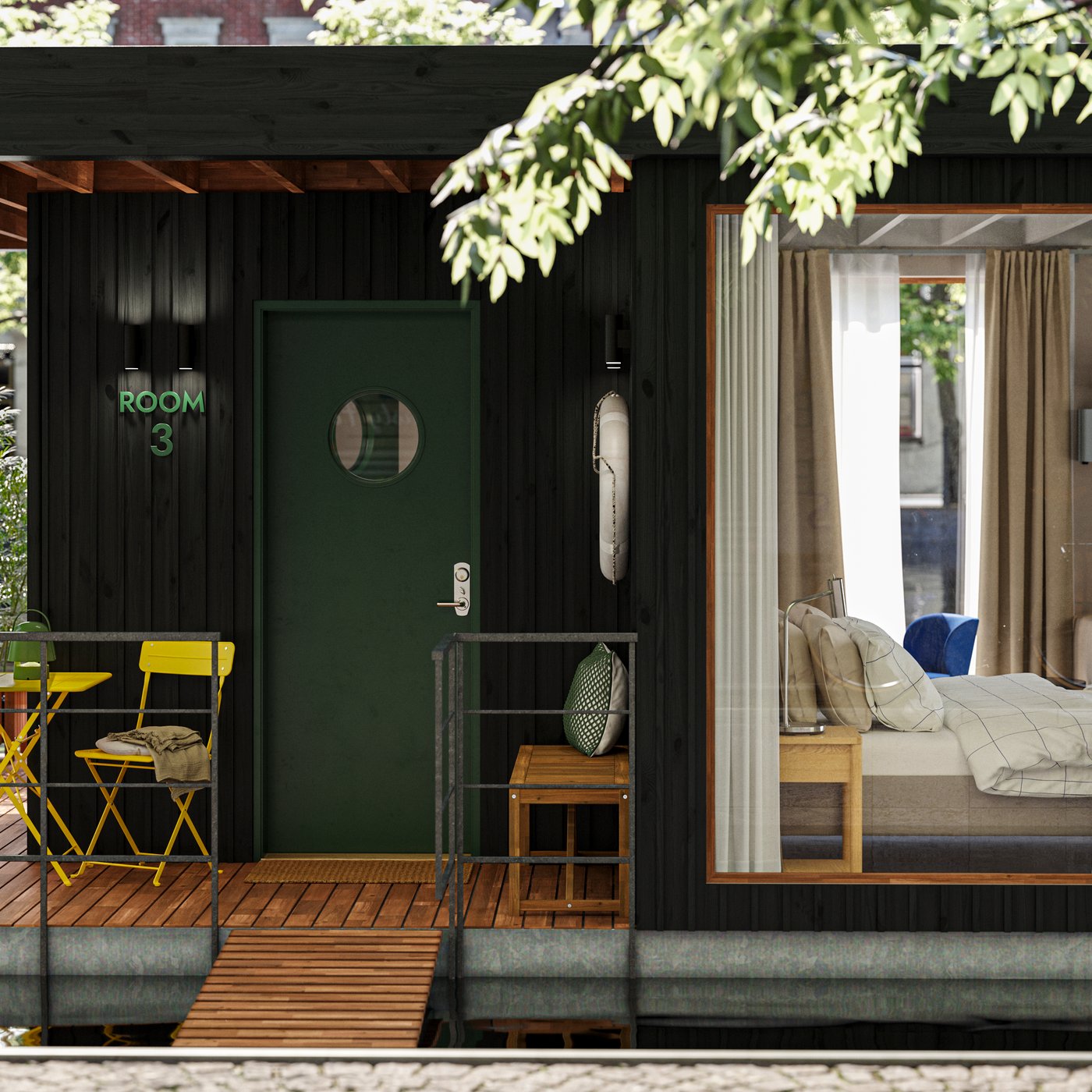 The deck of a small houseboat floating on the water in an urban setting. A room with a bed can be seen through a window.
