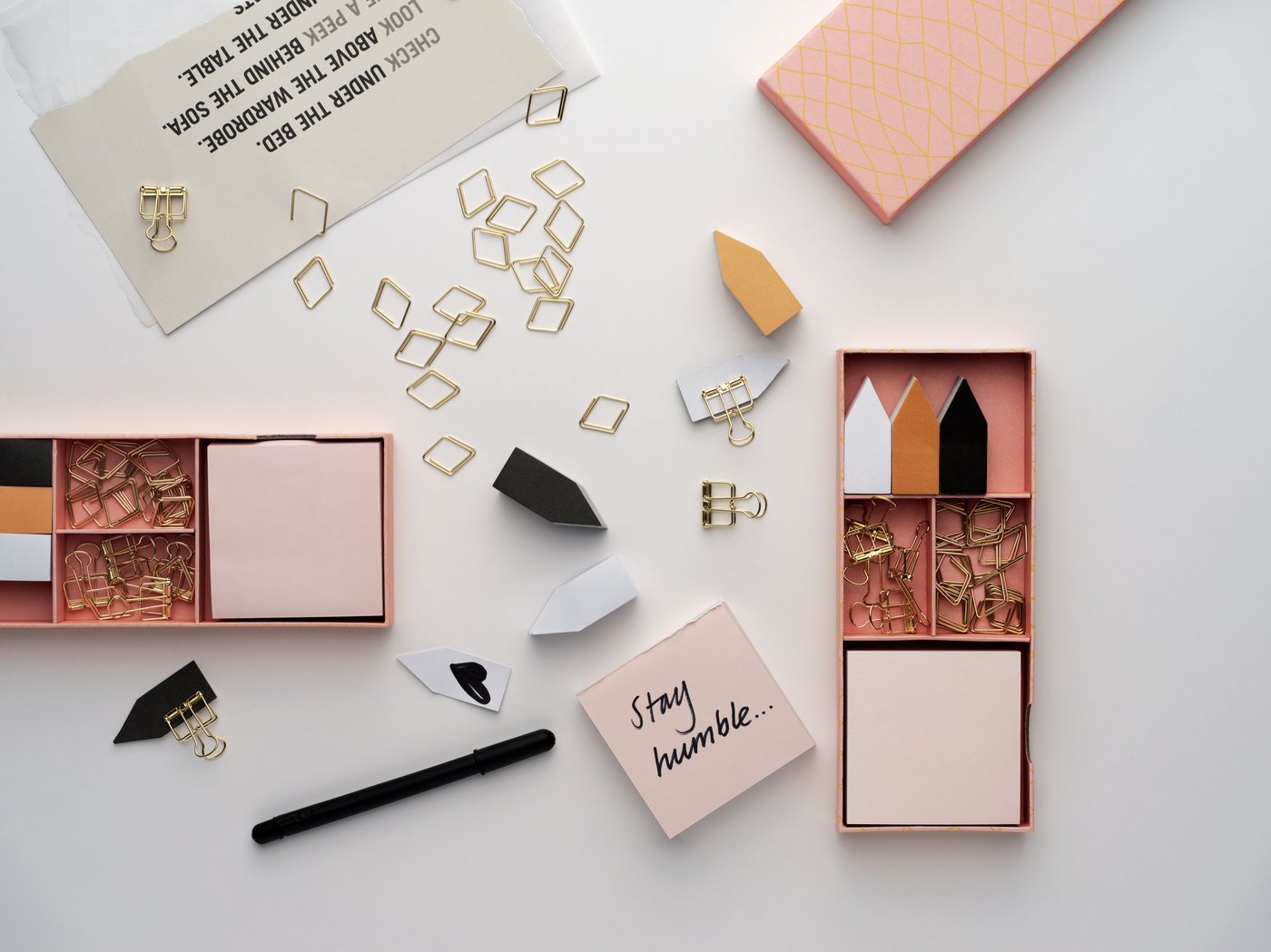 Pastel-coloured and metallic stationery scattered on a table.