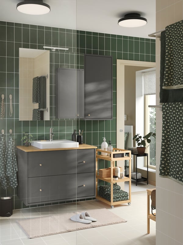 A dark grey/mélange HIMLEÅN bath towel in the bathroom
