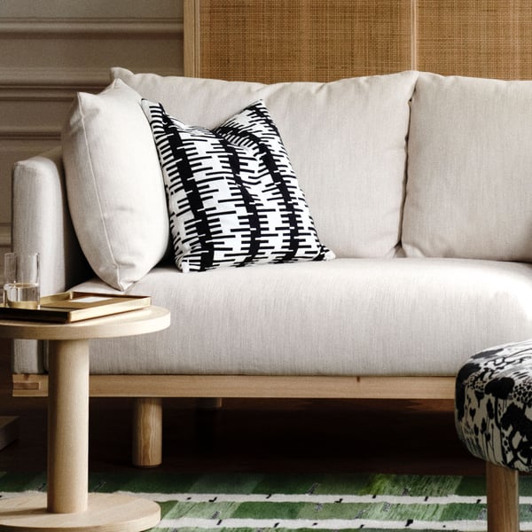 An off-white/black STOCKHOLM 2025 cushion cover in the living room